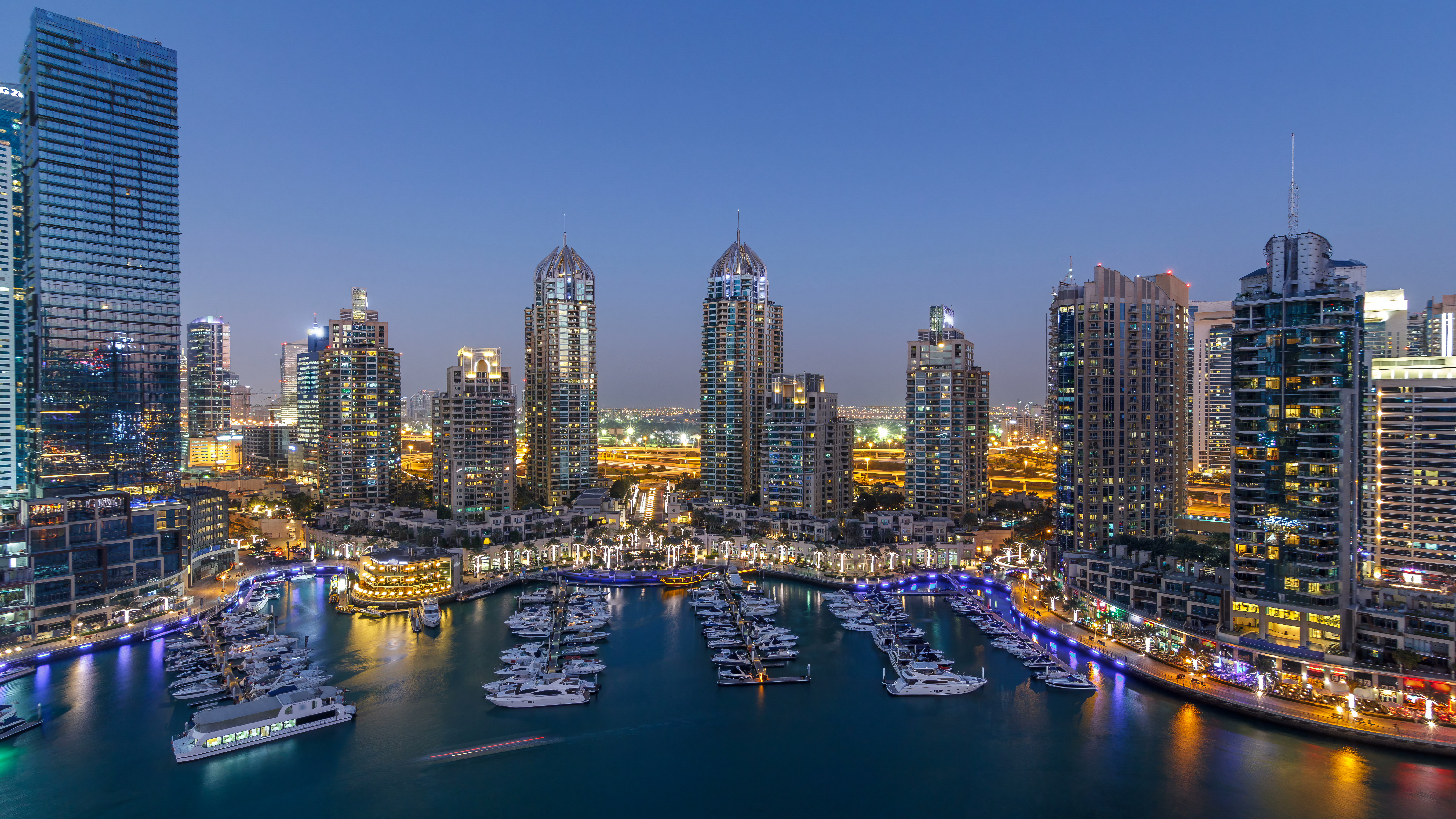 Dubai Marina skyscrapers aerial day to night timelapse, port with luxury yachts and marina promenade
